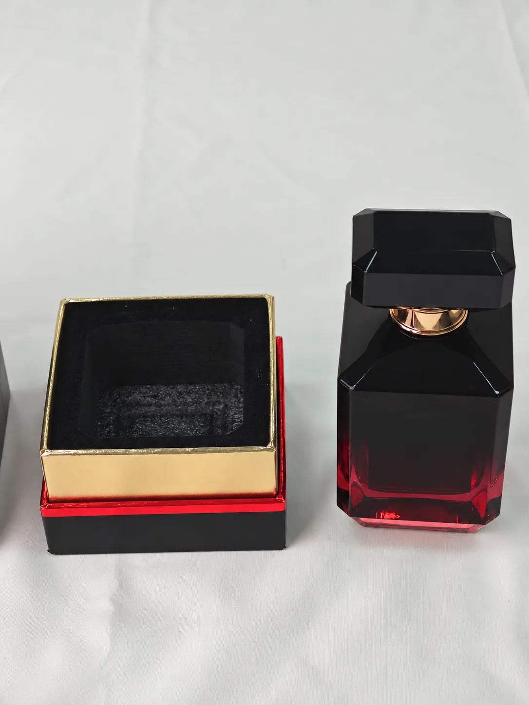 Perfume bottle beside an open outer box and fitted inner tray